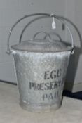 A GALVANISED 'EGG PRESERVING PAIL' AND COVER, bears indistinct raised letters and numbers above