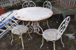 A WHITE PAINTED METAL GARDEN TABLE 100cm in diameter with scrolled tubular legs and four similar