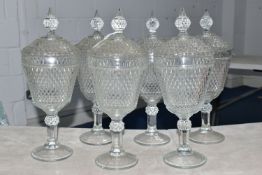 A SET OF SIX LATE 20TH CENTURY AMERICAN 'INDIANA GLASS' CLEAR PRESSED GLASS JARS AND COVERS OF