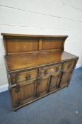 AN OAK PANELLED SIDEBOARD, with two drawers, and double cupboard doors, width 138cm x depth 53cm x