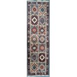 A 20TH PERSIAN CARPET RUNNER, with fourteen patterned lozenge, of various colours, 287cm x 84cm (