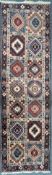 A 20TH PERSIAN CARPET RUNNER, with fourteen patterned lozenge, of various colours, 287cm x 84cm (