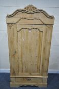 A FRENCH PINE PANELLED SINGLE DOOR ARMOIRE, with a foliate shaped cornice, and a single drawer,