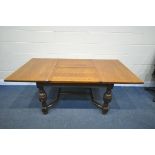 A 20TH CENTURY SOLID OAK DRAW LEAF TABLE, with a single fold out leaf, on block and acorn legs,