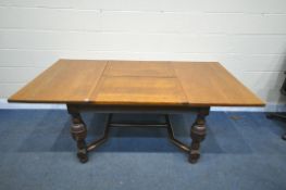 A 20TH CENTURY SOLID OAK DRAW LEAF TABLE, with a single fold out leaf, on block and acorn legs,
