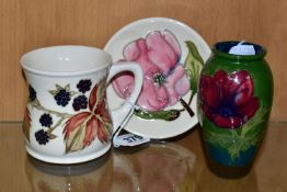 A COLLECTION OF MOORCROFT POTTERY, comprising a 'Blackberry' pattern mug, height 9cm, designed by