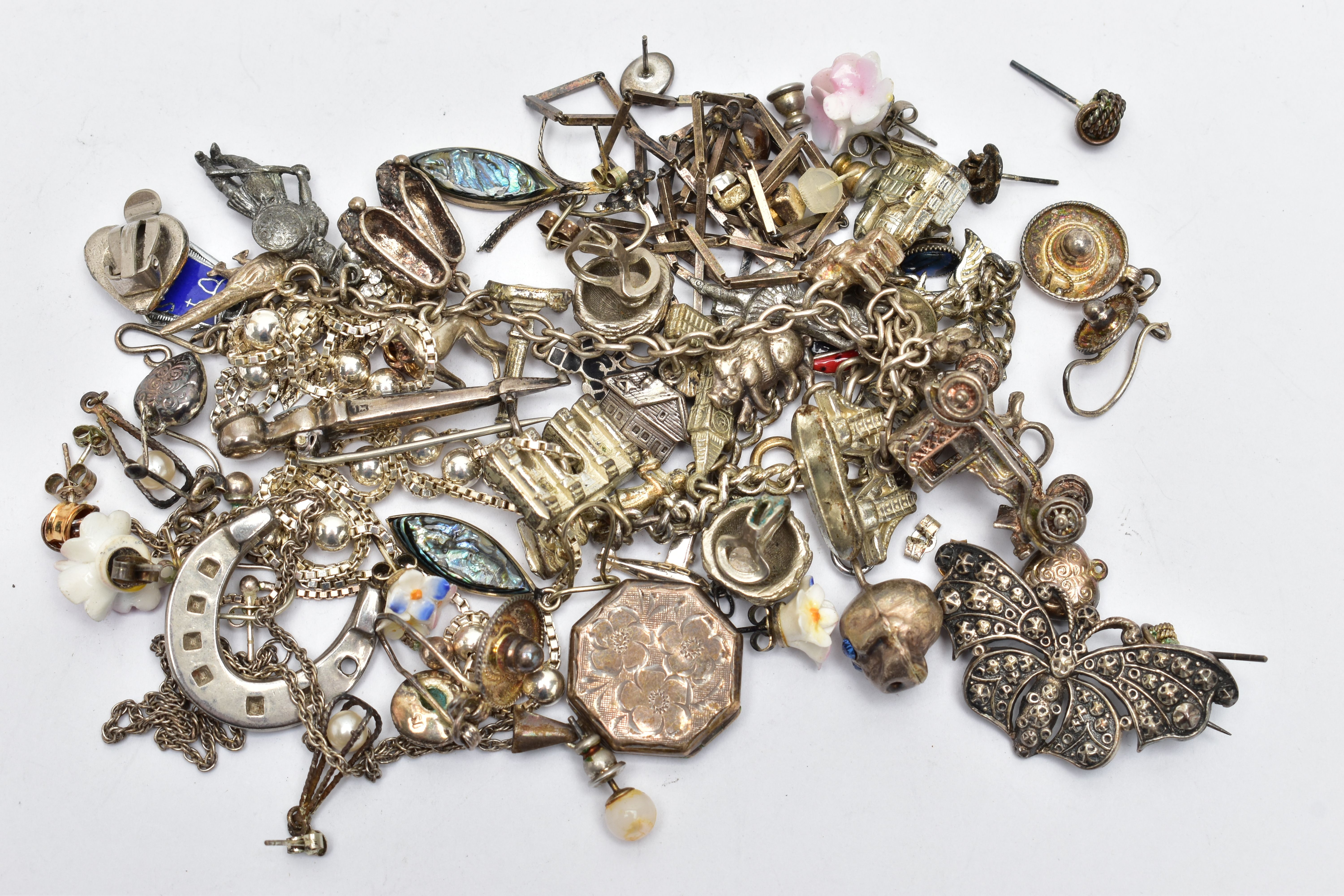 AN ASSORTMENT OF WHITE METAL JEWELLERY, to include a Scottish brooch, chain necklaces, two charm