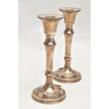 A PAIR OF SILVER CANDLESTICKS, each with a tapered stem, on round weighted bases, approximate height