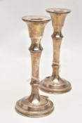 A PAIR OF SILVER CANDLESTICKS, each with a tapered stem, on round weighted bases, approximate height