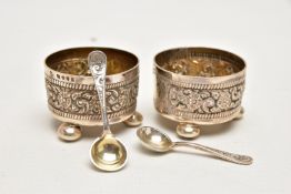 A PAIR OF LATE VICTORIAN SILVER SALTS, each decorated with an embossed floral pattern with vacant