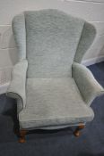 A MINT GREEN UPHOLSTERED WING BACK ARMCHAIR, and a glide motion rocking chair (condition - both in
