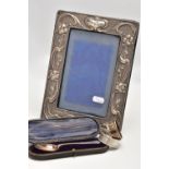 AN EDWARDIAN SILVER PHOTO FRAME, TWO NAPKIN RINGS AND A CASED TEASPOON, the rectangular photo