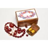 A SMALL WOODEN BOX WITH BAKELITE BEADS AND TWO CHEROOTS, the small wooden box with a painted