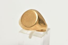 A YELLOW METAL SIGNET RING, oval form signet with tapered shoulders, approximate width 16mm, stamped