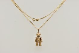 A 9CT GOLD ARTICULATED TEDDY BEAR PENDANT AND CHAIN, realistically textured, articulated teddy