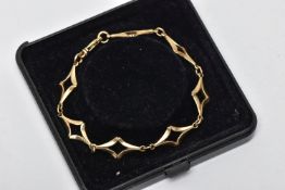 A 9CT GOLD FANCY LINK BRACELET, designed with a series of openwork diamond shape links, with jump