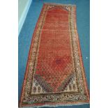 A 20TH CENTURY IRANIAN RED PATTERNED CARPET RUNNER, 300cm x108cm (condition:-patch repair)
