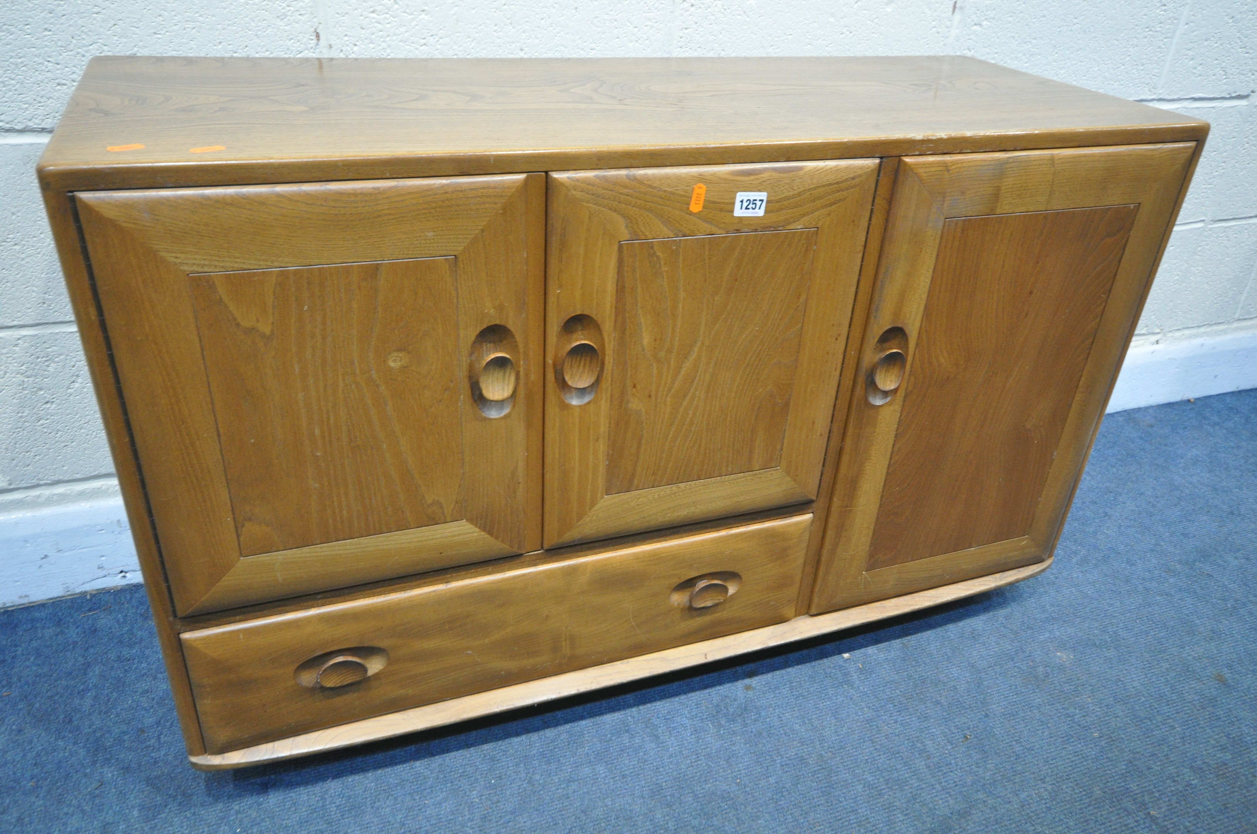 AN ERCOL BLONDE ELM SIDEBOARD, with double cupboard doors over a single drawer flanked by a single