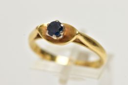 A YELLOW METAL SINGLE STONE RING, designed with a six claw set, circular cut blue sapphire, within a