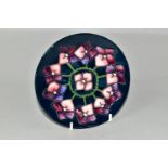 A MOORCROFT POTTERY PLATE DECORATED WITH A VIOLETS PATTERN, dark blue ground, impressed and