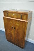 AN ART DECO QUARTER VENEERED BURR WALNUT TALLBOY, with a single drawer and double cupboard doors,