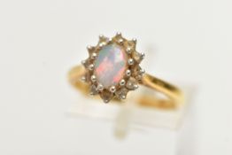 A 18CT GOLD OPAL CLUSTER RING, a single cabochon set with a surround of round brilliant cut