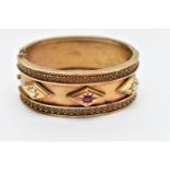 A LATE VICTORIAN GEM SET HINGED BANGLE CIRCA 1890, set with a cushion shape ruby and two split