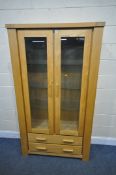 A MORRIS FURNITURE LIGHT OAK BOOKCASE, with two glazed doors, enclosing three glass shelves, above