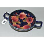 A WILLIAM MOORCROFT TWIN HANDLED FOOTED BOWL DECORATED WITH POMEGRANATE PATTERN ON A DARK BLUE