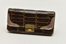 AN EARLY 20TH CENTURY CROCODILE SKIN PURSE, mounted with two 9ct rose gold hard wear corners to