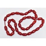 A CHERRY AMBER BAKELITE BEAD NECKLACE, designed with a single row of thirty-five barrel shape beads,