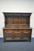 A 20TH CENTURY SOLID OAK DRESSER, the top with a fixed overhanging cornice, and three carved panels,