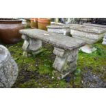 A WEATHERED COMPOSITE GARDEN BENCH, on a twin scrolled base, length 97cm x depth 37cm x height