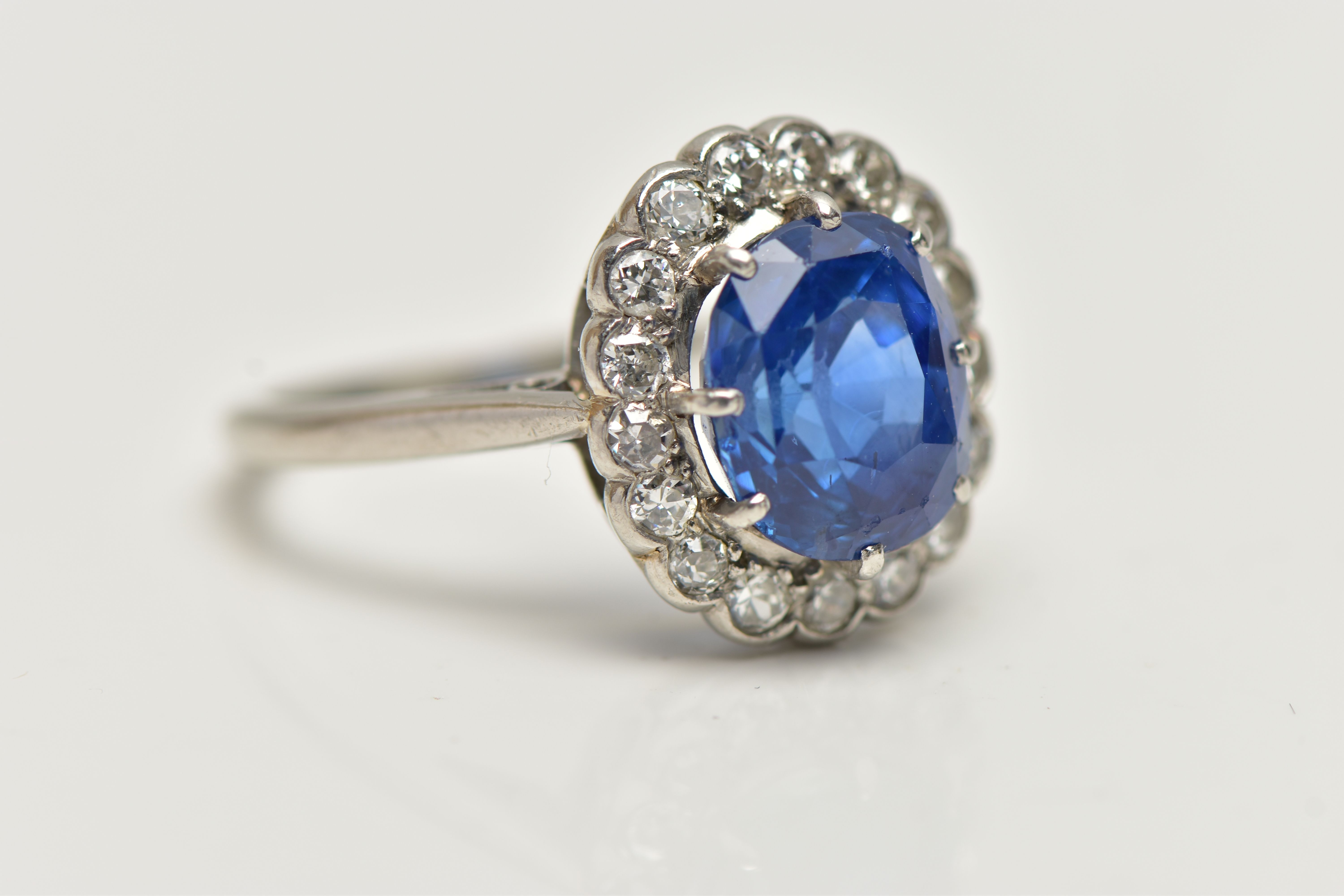 A SAPPHIRE AND DIAMOND CLUSTER RING, set with a mixed cut, cushion sapphire, measuring approximately - Image 6 of 13