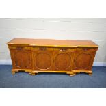 A YEWWOOD BREAKFRONT SIDEBOARD, with four drawers and cupboards, on ogee bracket feet, width 211cm x