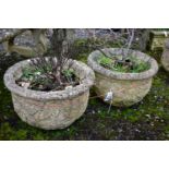 A PAIR OF WEATHERED COMPOSITE CIRCULAR PLANTERS, with a floral design, diameter 53cm x height