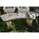 A WEATHERED COMPOSITE CURVED BENCH, on a pair of squirrel shaped bases, length 115cm (condition:-