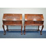 A PAIR OF ORIENTAL CARVED HARDWOOD BUREAU'S, the fall front enclosing a fitted interior, above two