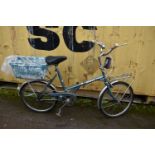 A VINTAGE DAWES KINGPIN FOLDING BIKE in metallic blue, with 17in frame, rear basket and front rack