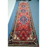 A 20TH CENTURY IRANIAN EAGLE KAZAK STYLE CARPET RUNNER, 445cm x 117cm