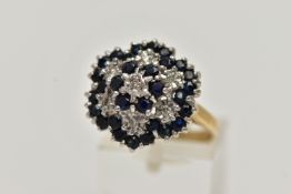 A 9CT GOLD CLUSTER RING, seven single cut diamonds set with thirty circular cut blue sapphires,