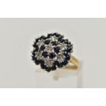 A 9CT GOLD CLUSTER RING, seven single cut diamonds set with thirty circular cut blue sapphires,