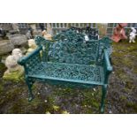 A VICTORIAN STYLE HEAVY CAST IRON GARDEN BENCH, with leaf and vines shaped back, rams head