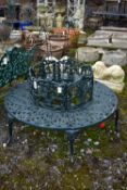 A CAST ALUMINIUM ROUND TREE BENCH, decorated with still life flowers to the backrest, scrolls to the