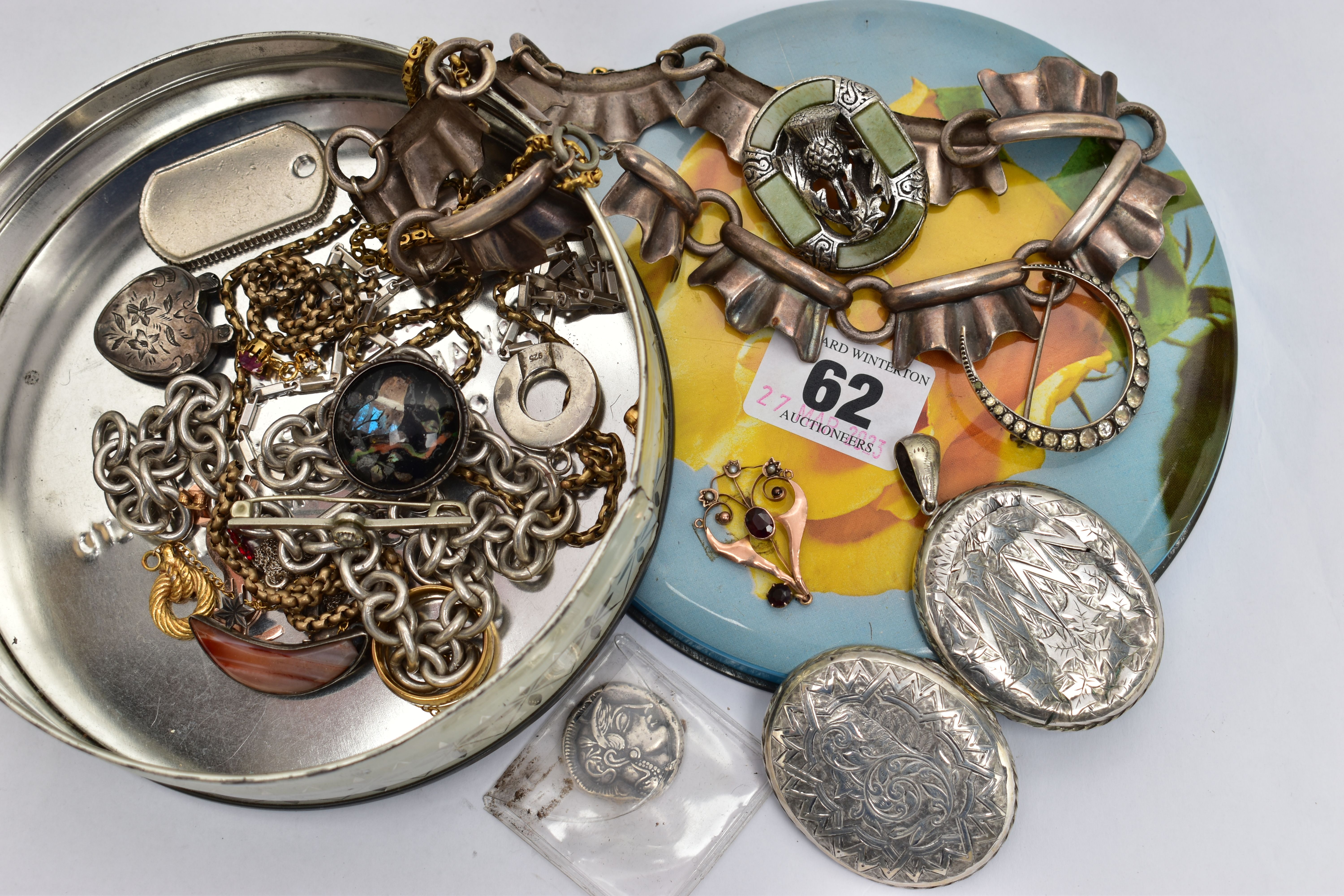 A SMALL TIN OF ASSORTED ITEMS, to include a rose metal lavalier pendant set with garnet and split