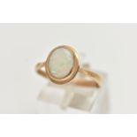 A 9CT GOLD OPAL RING, designed with an oval opal cabochon, collet set to the yellow gold rim,