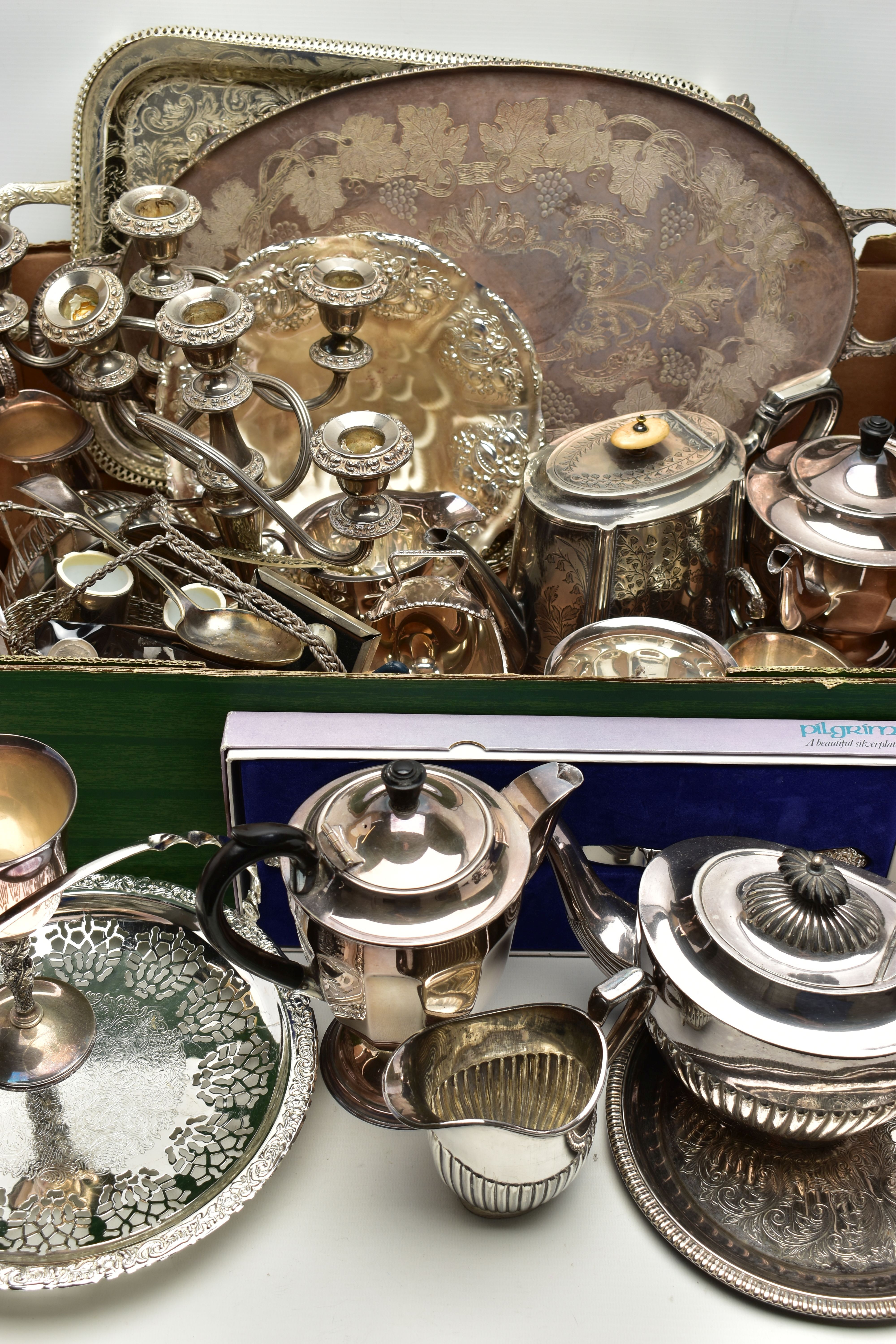 A BOX OF ASSORTED WHITE METAL WARE, to include two trays, a pair of candelabras, a sugar caster, a