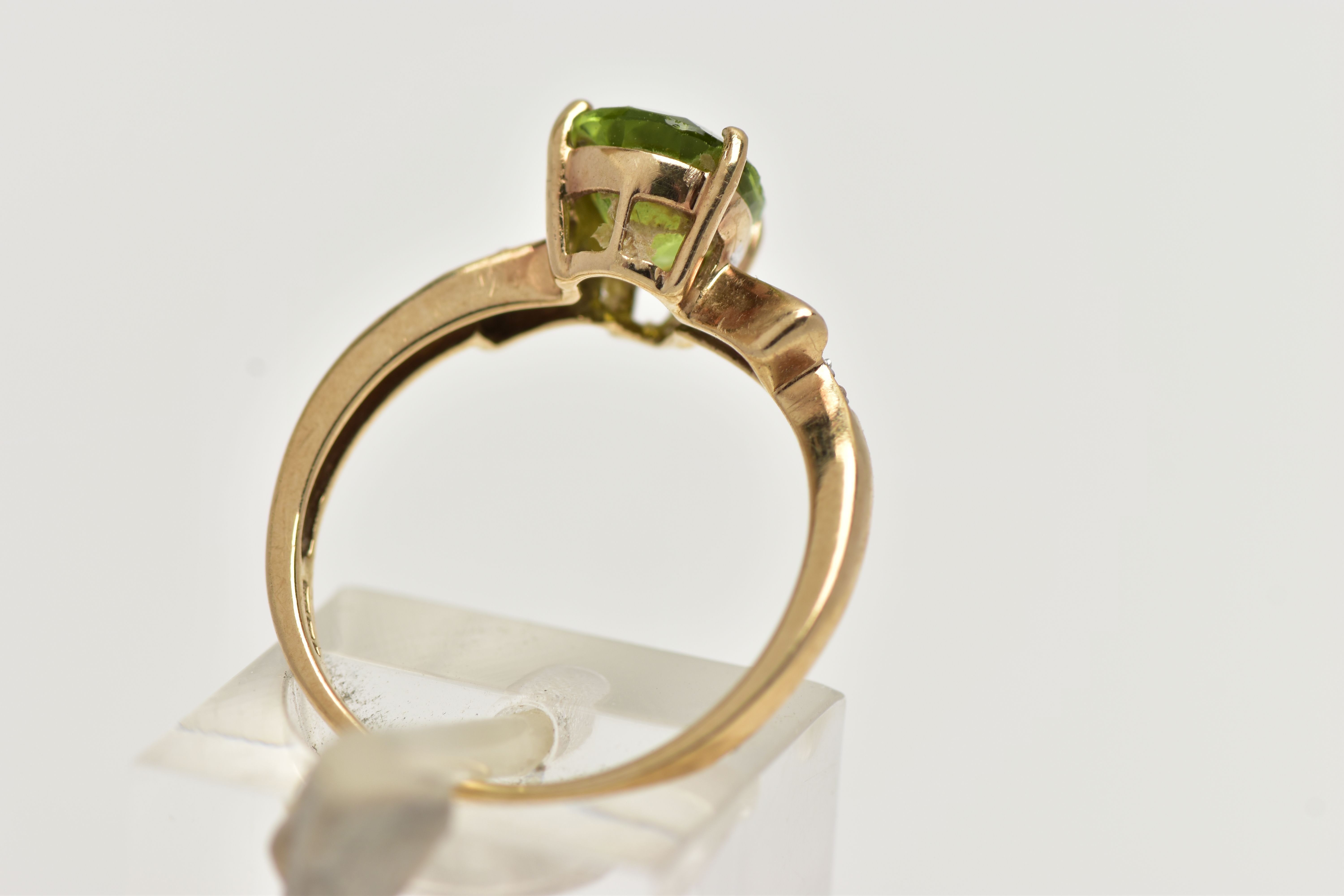 A 9CT GOLD, PERIDOT AND DIAMOND RING, designed with a four claw set, pear cut peridot, flanked - Image 3 of 4