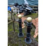 A PAIR OF CAST IRON PILLAR POSTS, with a gold painted finial, height 82cm with rusted chains,