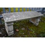 A WEATHERED COMPOSITE GARDEN BENCH, on twin scrolled supports, length 106cm x depth 39 x height